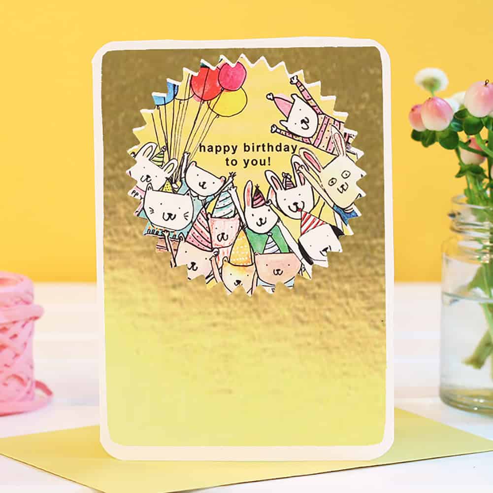 Gold birthday card with rabbits, balloons, and happy birthday to you message