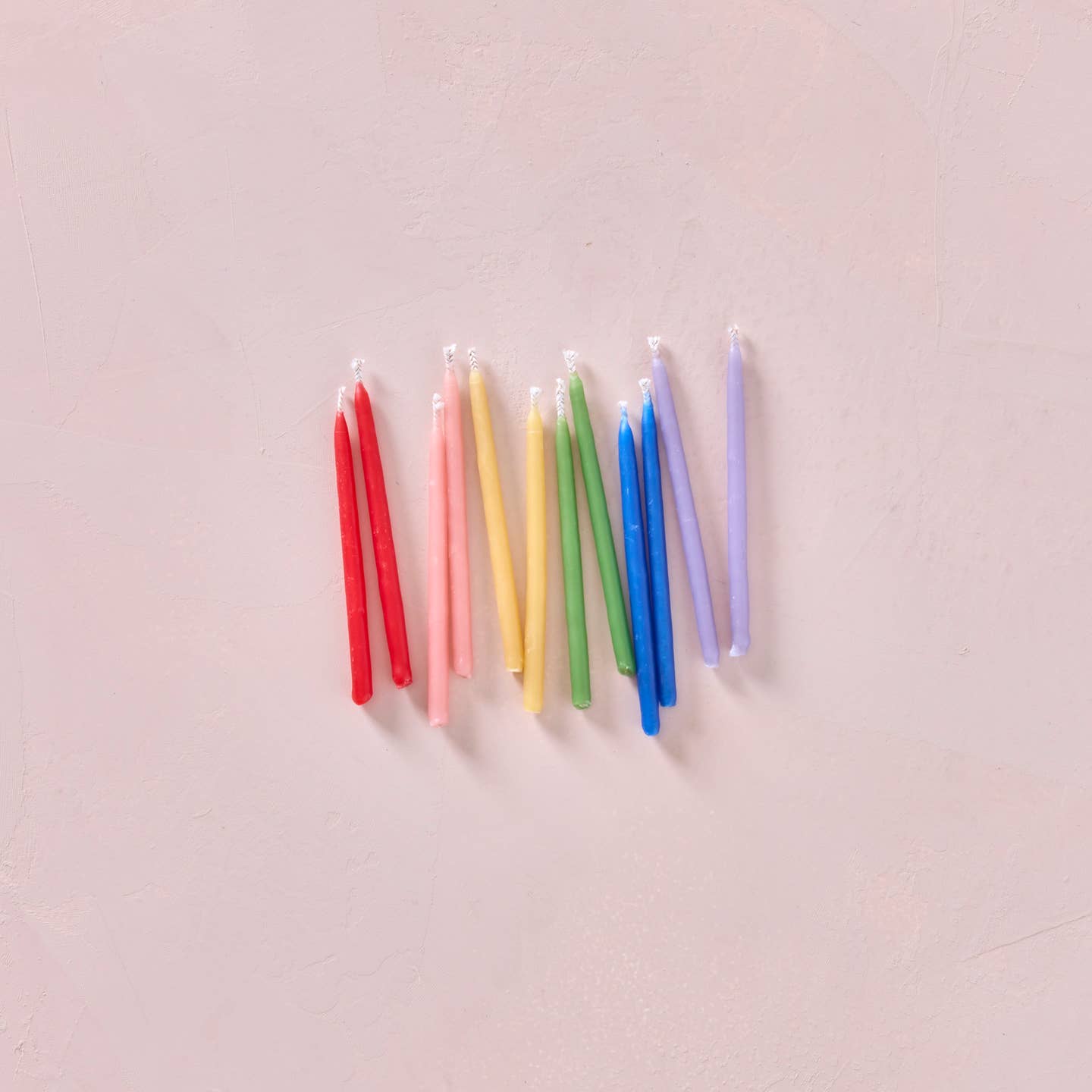 Multicolor beeswax party candles, slender rainbow tapers with white wicks