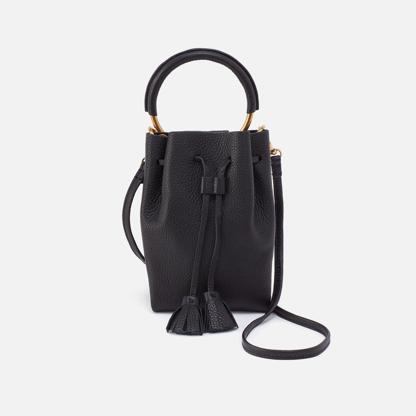Black phone crossbody bag with top handle, tassel pull and magnetic front pocket.