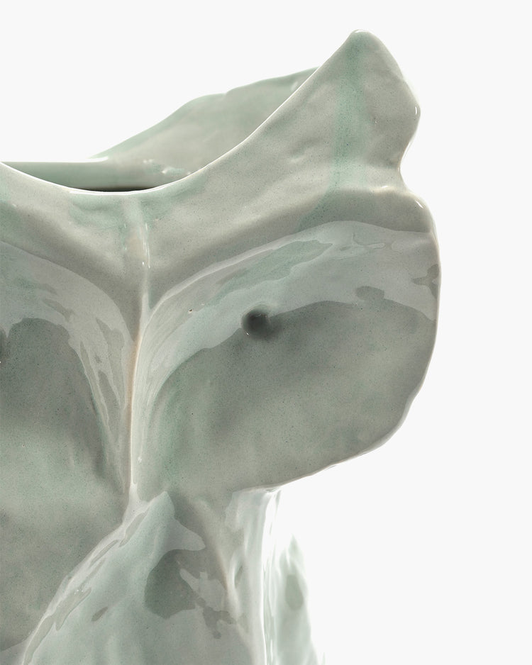 Glazed light gray owl vase close-up of head and raised wing detail