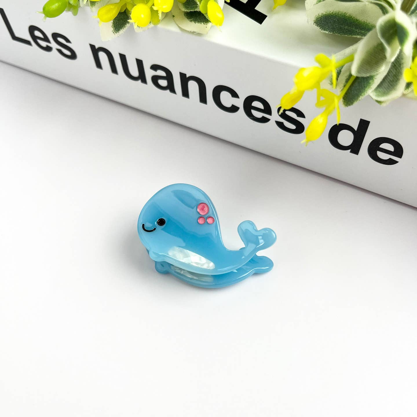 Light blue whale mini hair claw clip with molded eyes and pink detail