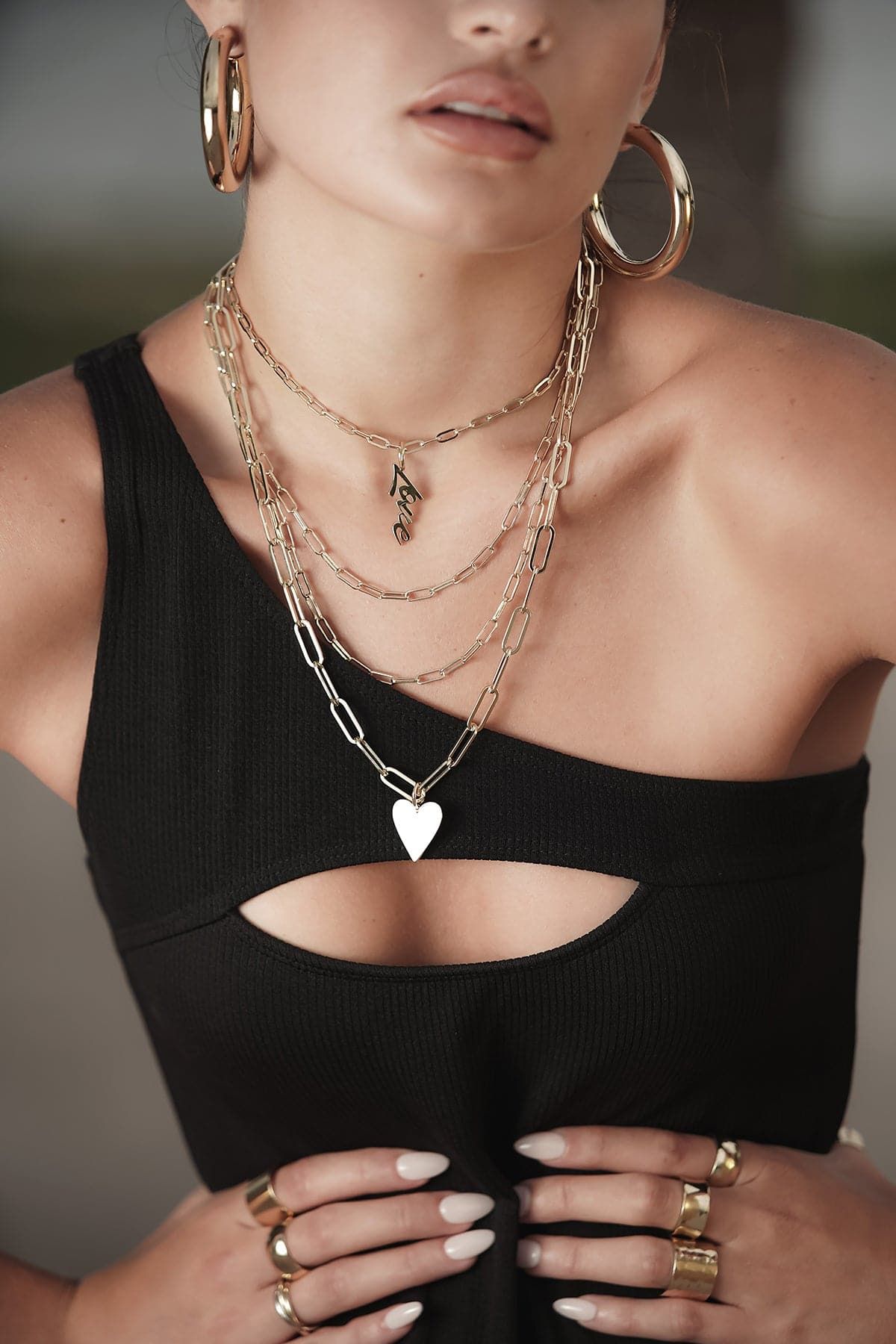 Gold-tone medium link chain necklace worn layered with other chains