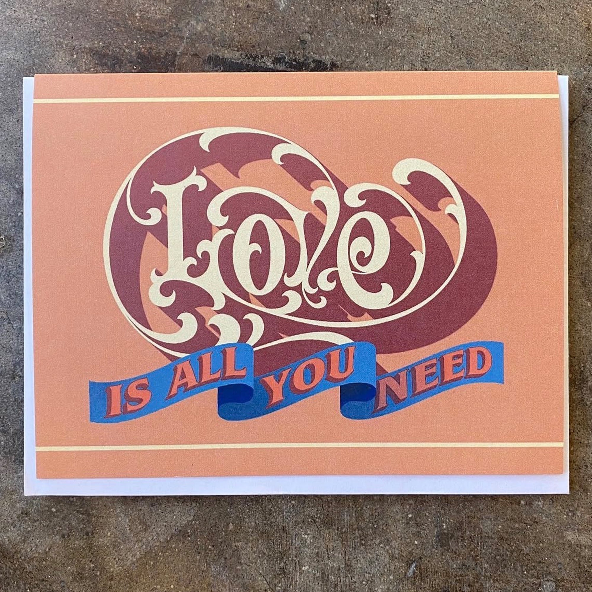 Love-themed greeting card, purple heart graphic and blue text: 'IS ALL YOU NEED'.