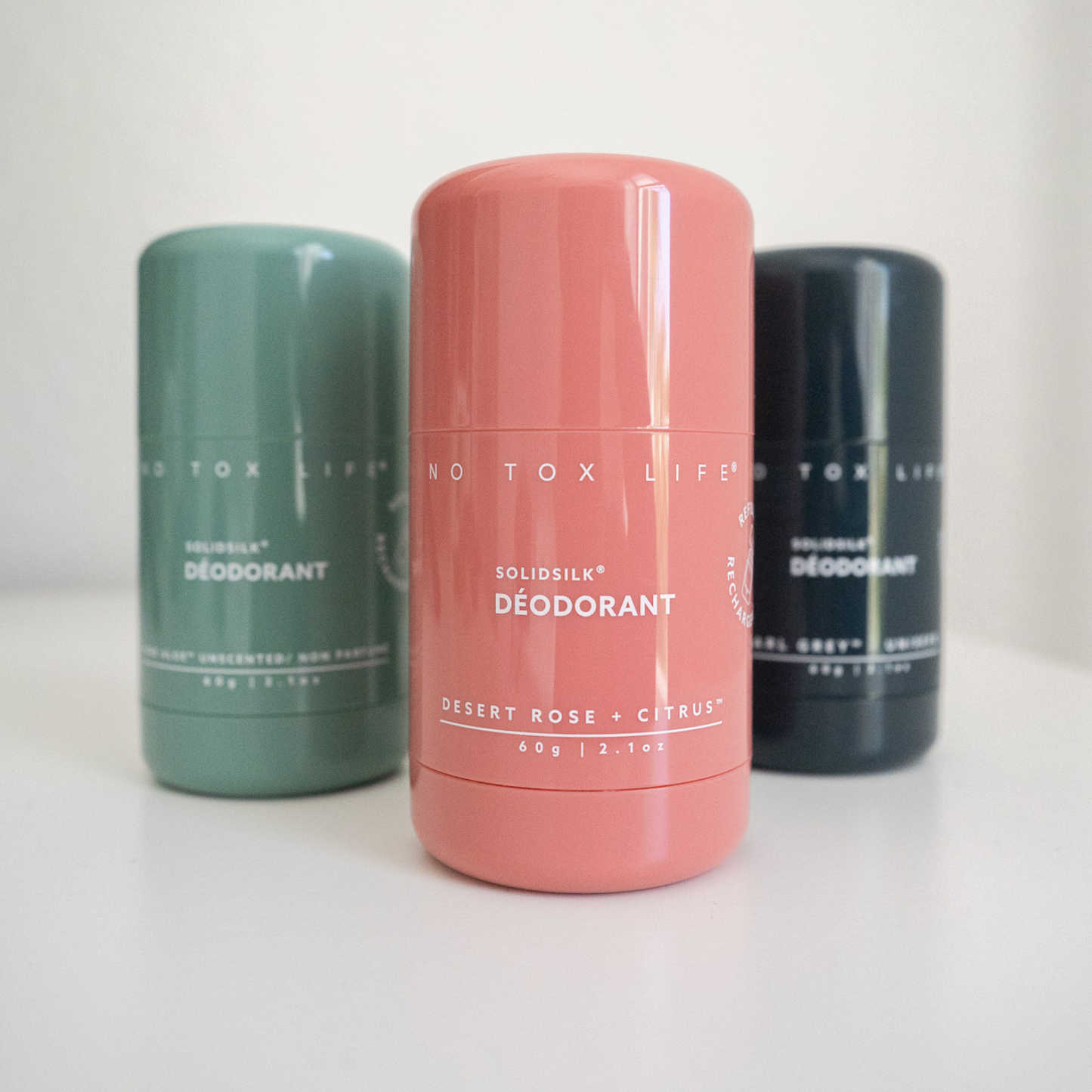 Refillable solid deodorant sticks, teal, rose, and dark charcoal containers