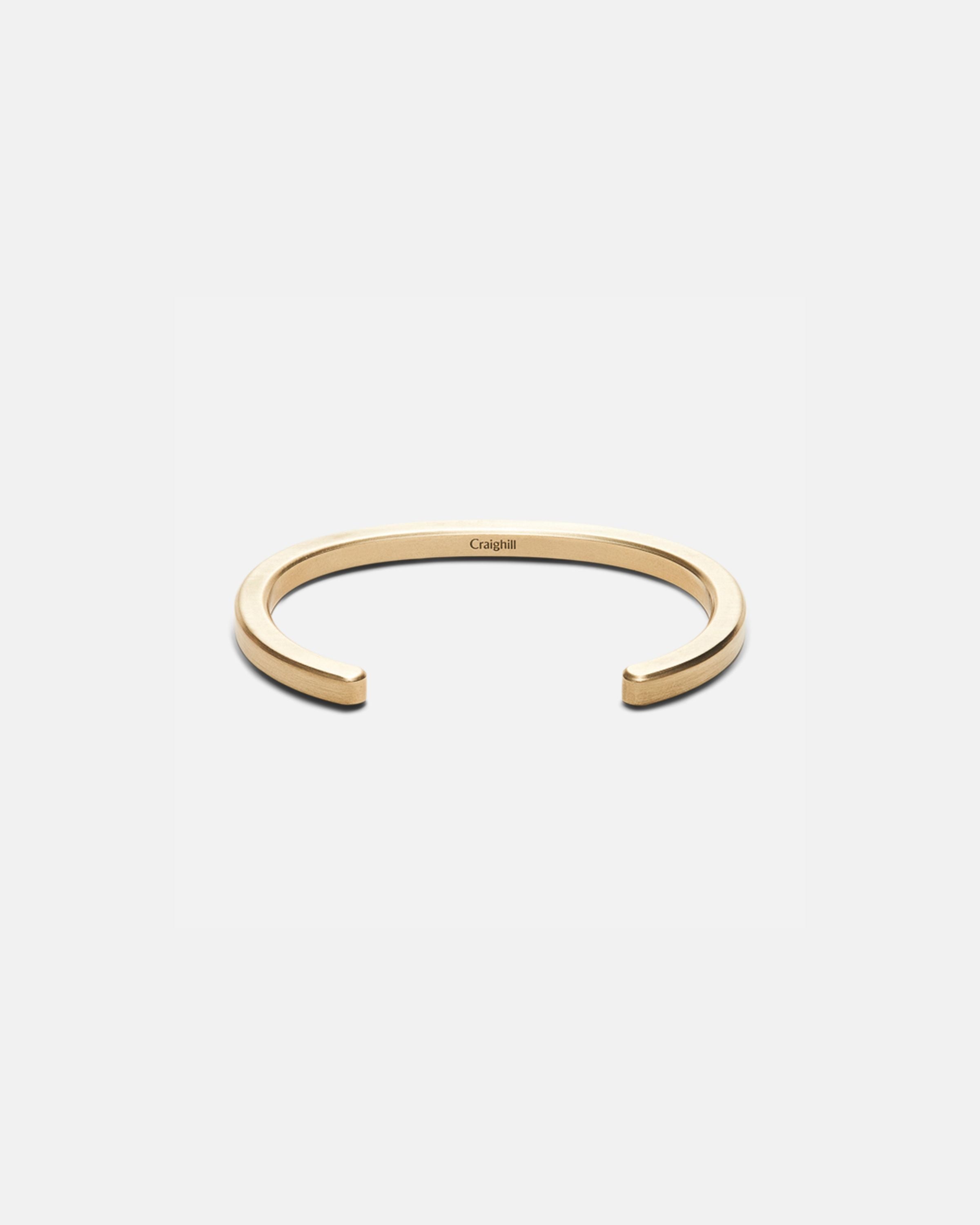 Brass cuff bracelet with open C-shape and radial cutout design