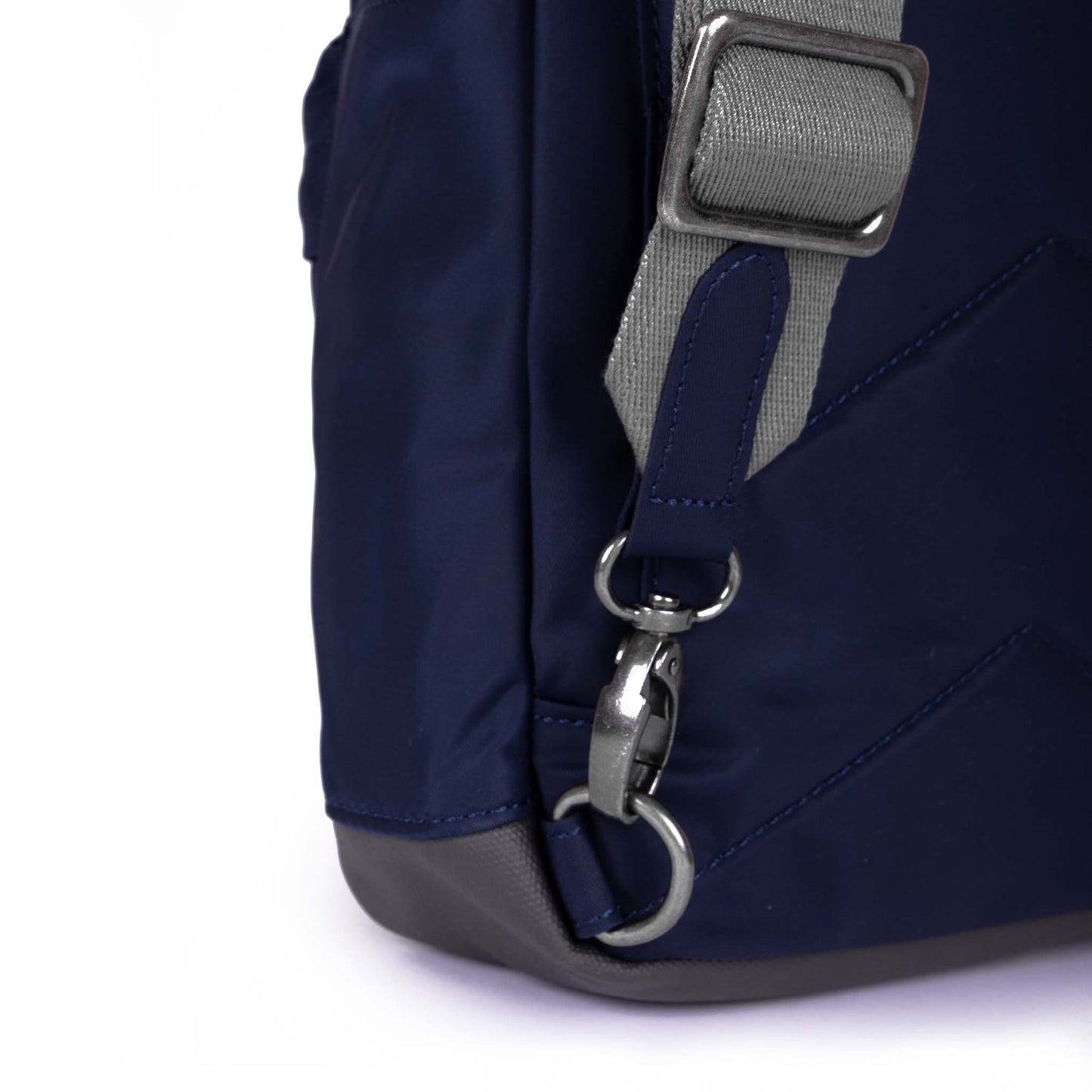 Dark blue sling bag side with gray strap webbing and metal D-ring hardware