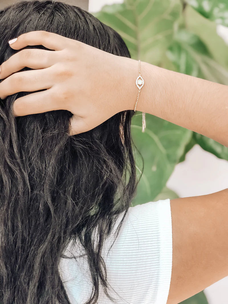 Gold-plated Pharaoh bracelet on wrist with oval blue pendant and link chain