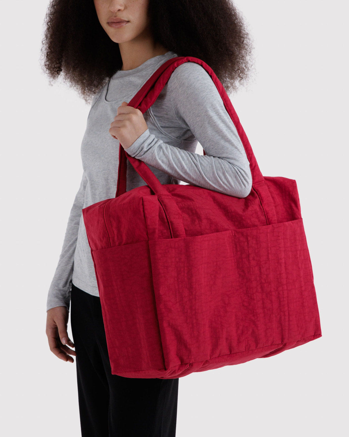 Red tote bag with two top handles carried over the shoulder