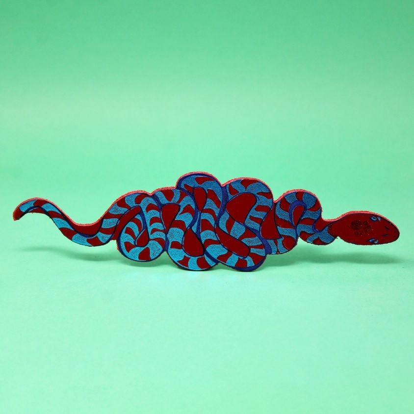 Snake bookmark with dark red head and blue patterned body, curled