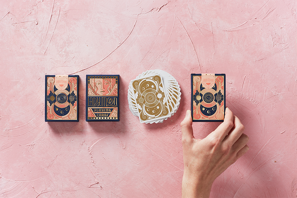 Moon-themed playing cards arranged in a row, hand holding one card