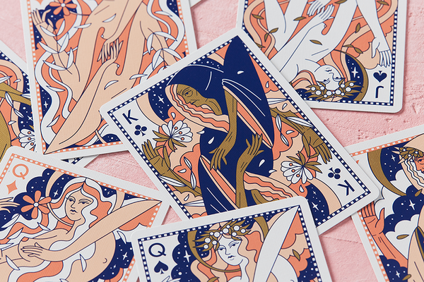 Moon-themed playing cards fanned out with navy and peach court and star designs