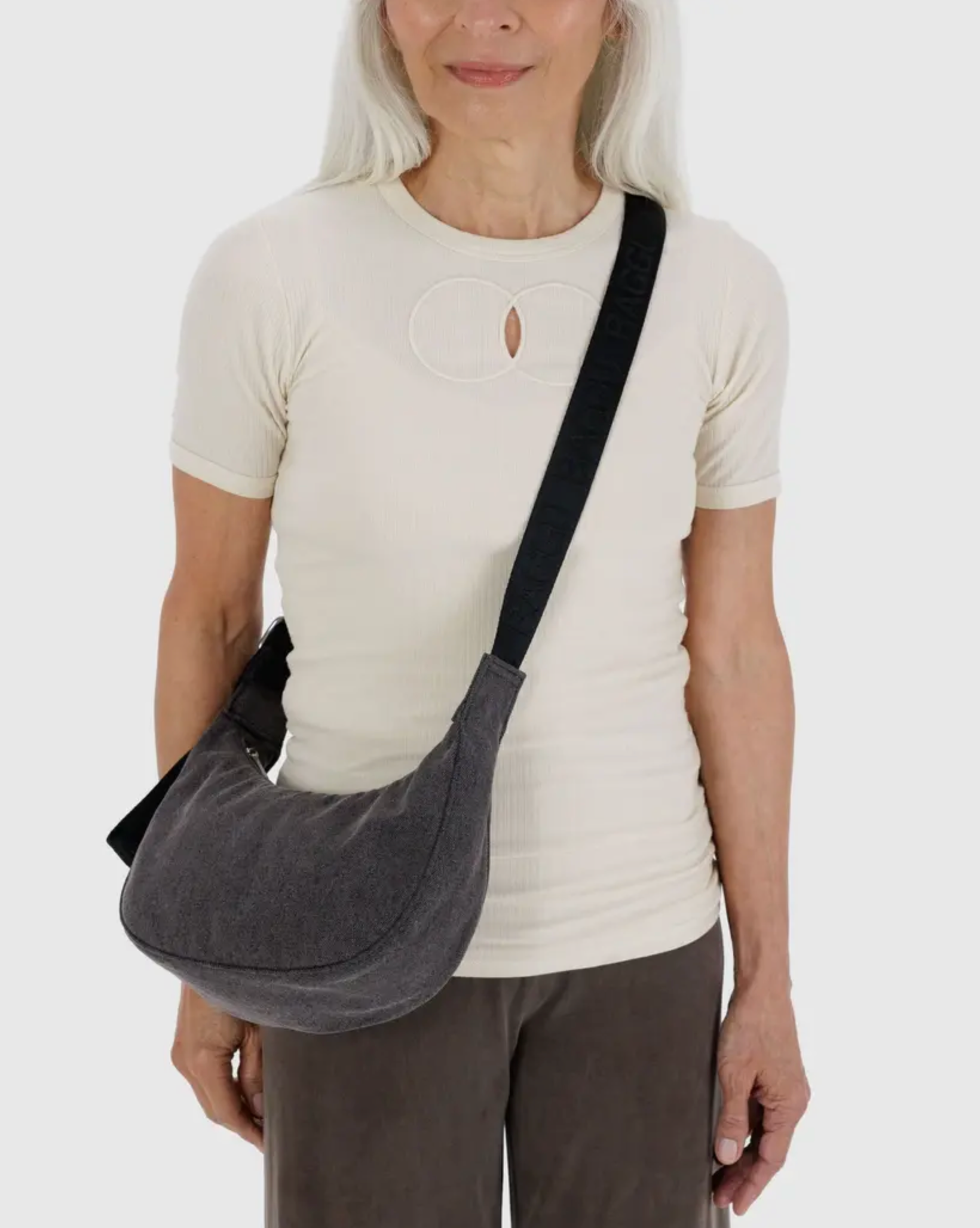 Washed black denim crescent crossbody bag with adjustable strap and curved shape
