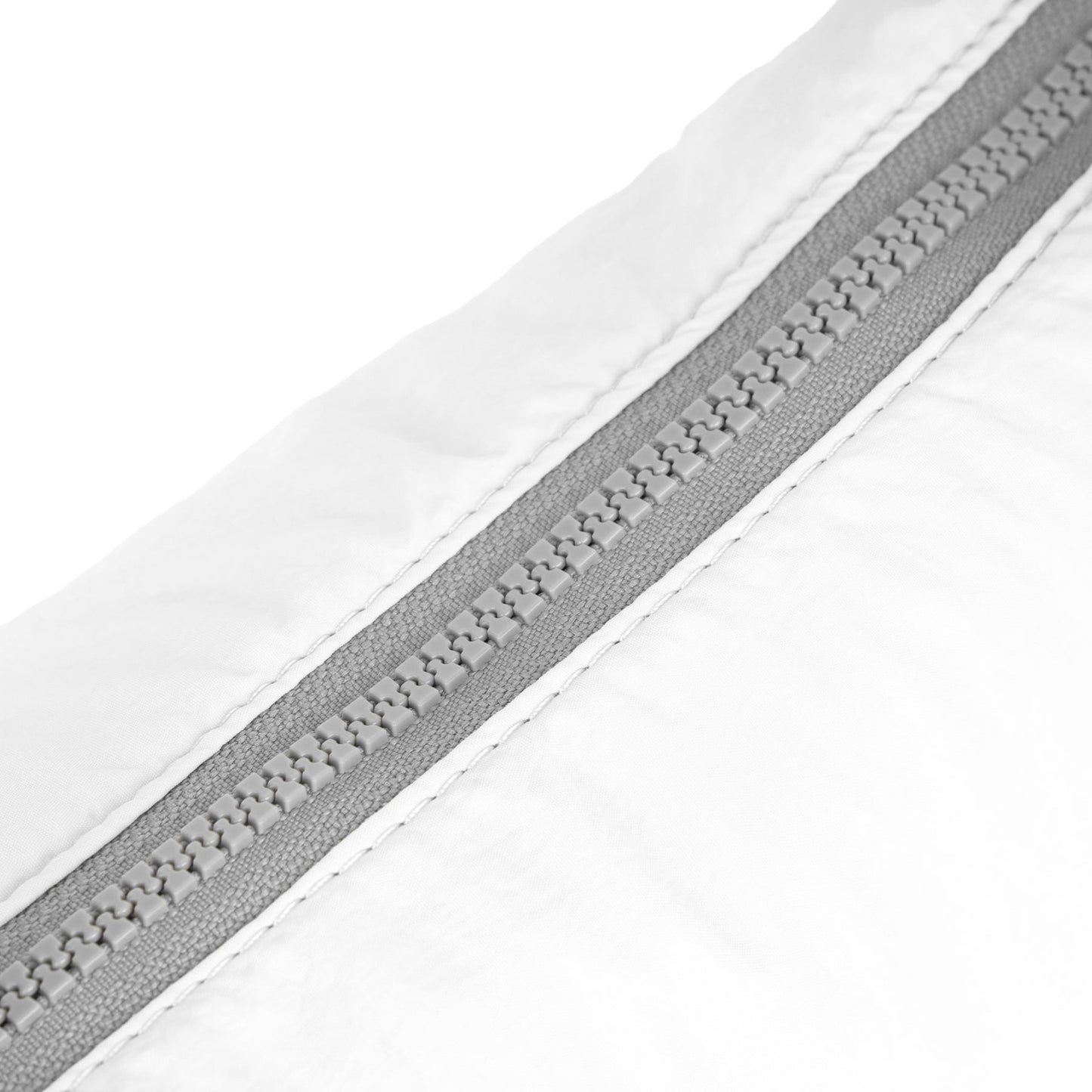 Coconut half-moon bag zip seam detail with gray zipper track and white fabric.