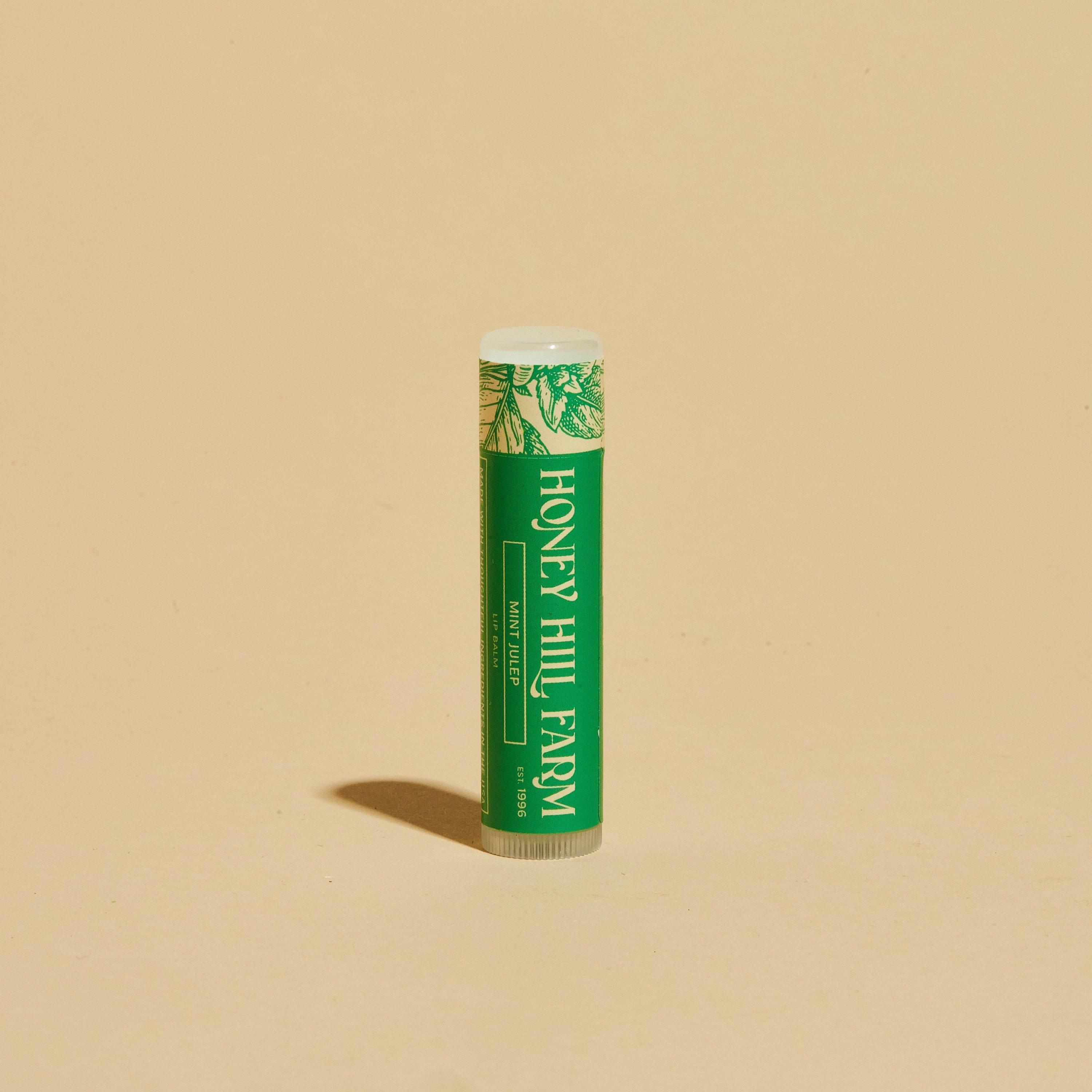 Lip balm tube with green label and white cap