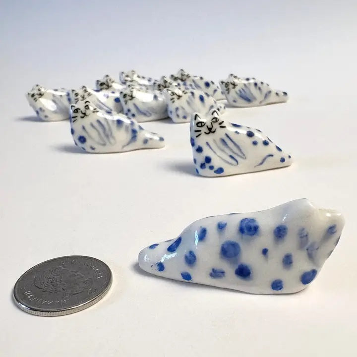 Blue leopard cat figurine beside a coin for size, white and dark blue dots
