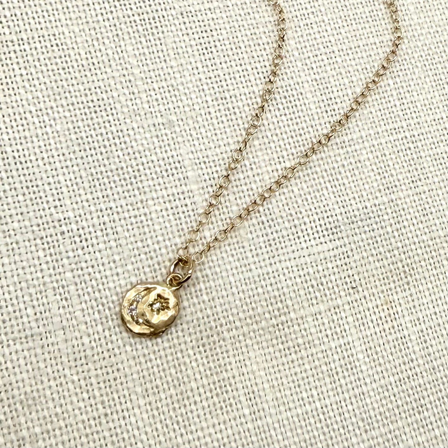 14k gold crescent and star charm pendant on delicate chain, close-up