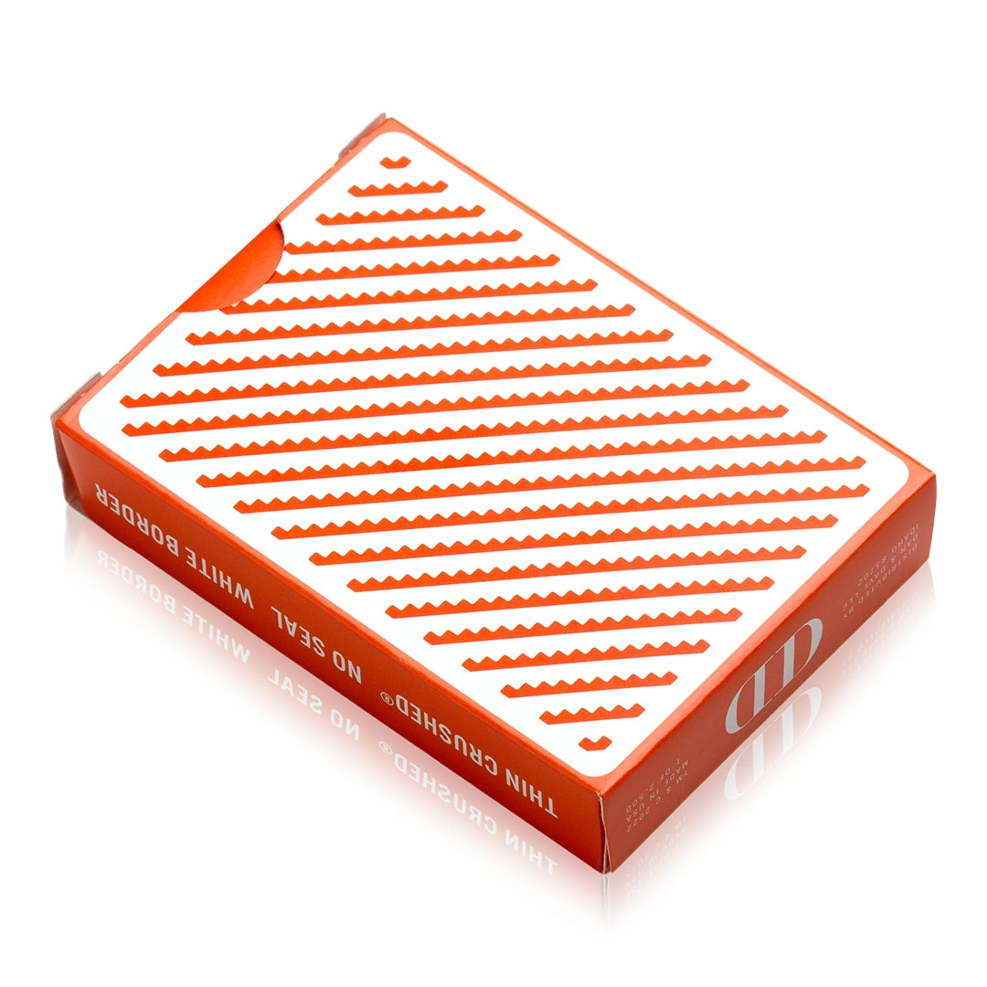 Orange playing card deck box top with white stripe pattern and red "Damn Good Cards"