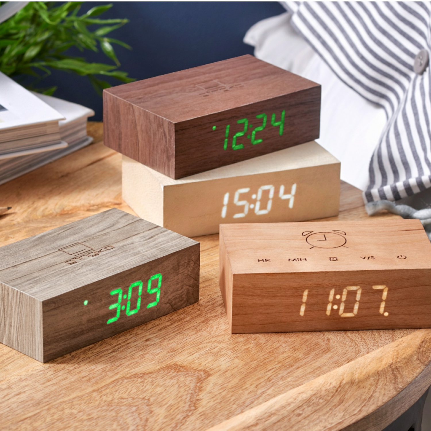 Wooden Flip Click Clock blocks with green LED times stacked on a desk surface