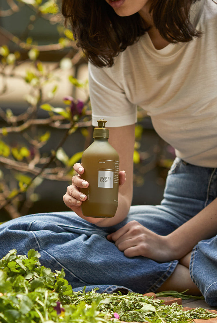 Dish wash bottle held in hands, olive green with pump label
