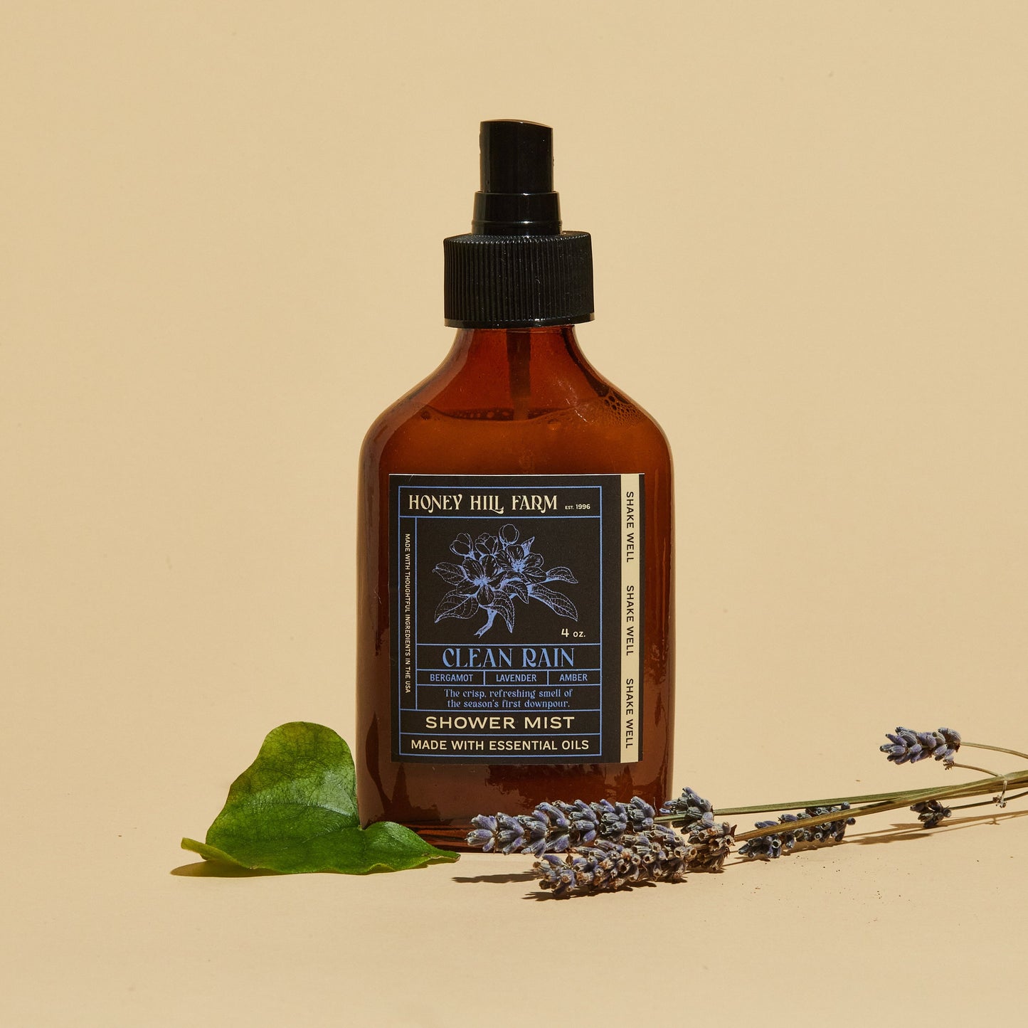 Shower mist spray bottle, amber glass and black pump; Clean Rain scent.