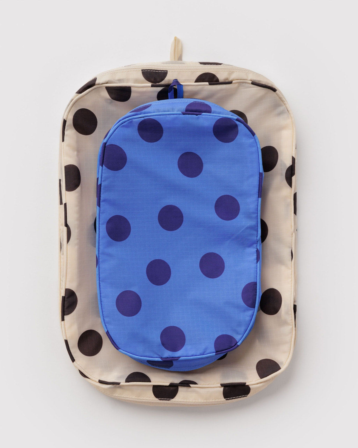 Packing cube set with beige polka-dot shell and blue polka-dot inner cube, zippered front.