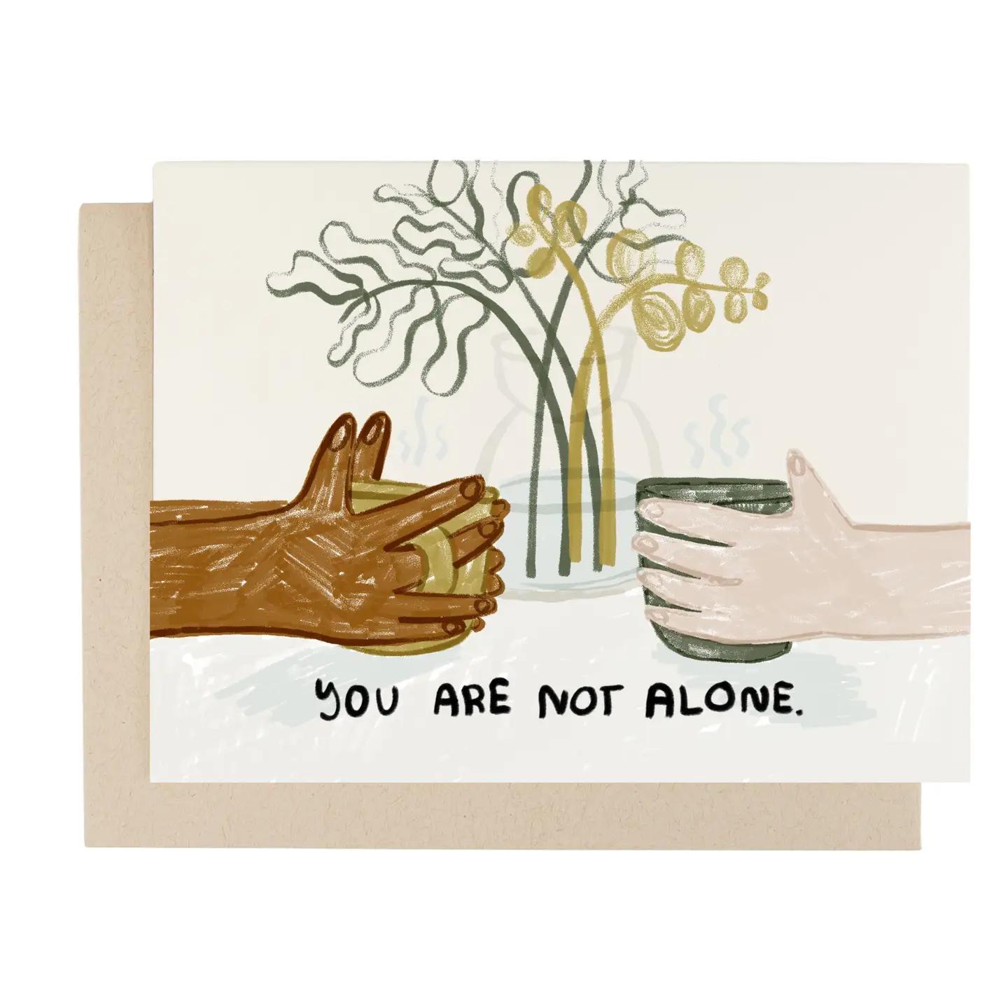 Greeting card with illustrated hands, flowers, and message "You are not alone"; with envelope
