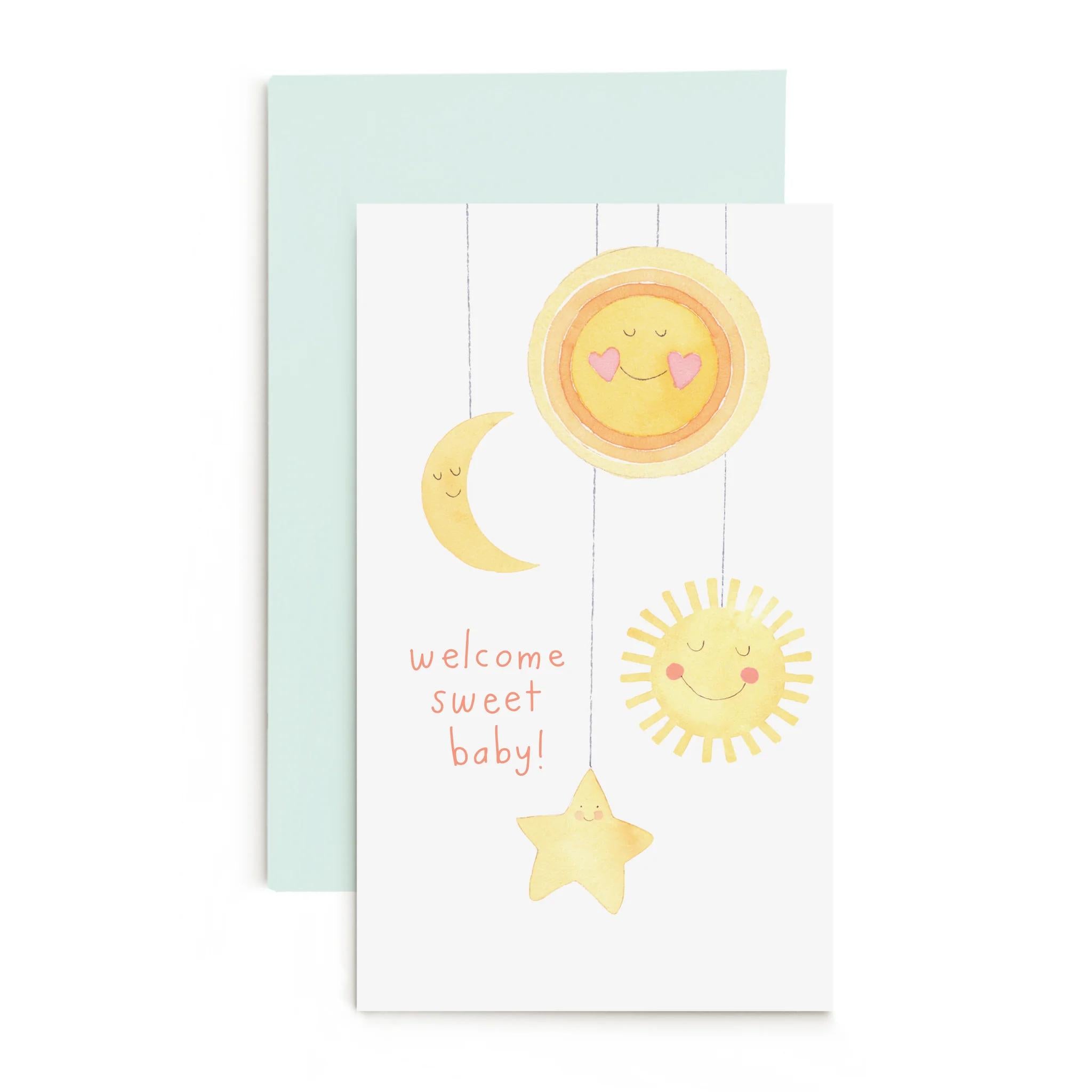 Baby mobile enclosure card with moon, sun, star motifs and “welcome sweet baby” text