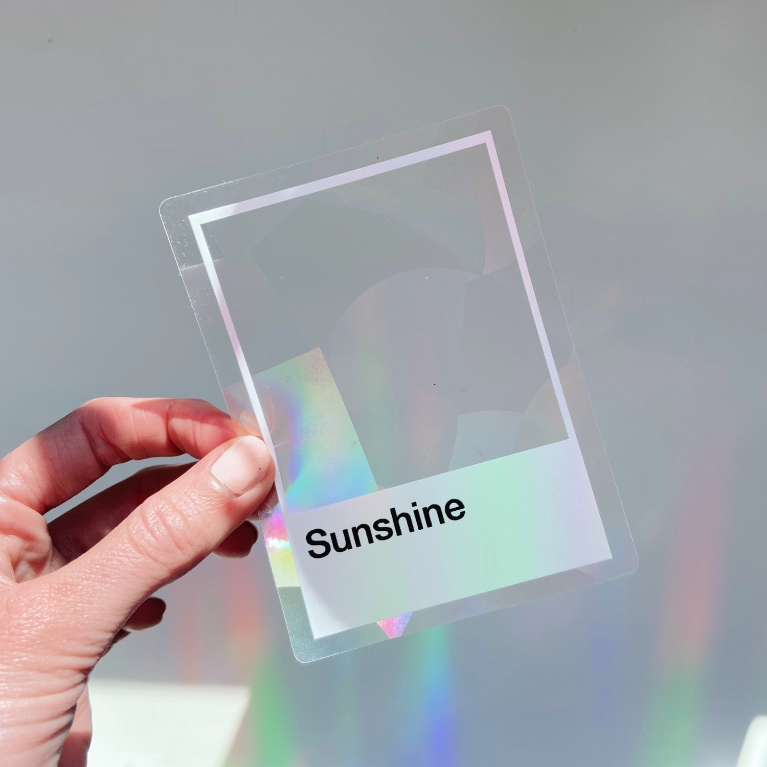 Hand-held small holographic square sticker with 'Sunshine' text
