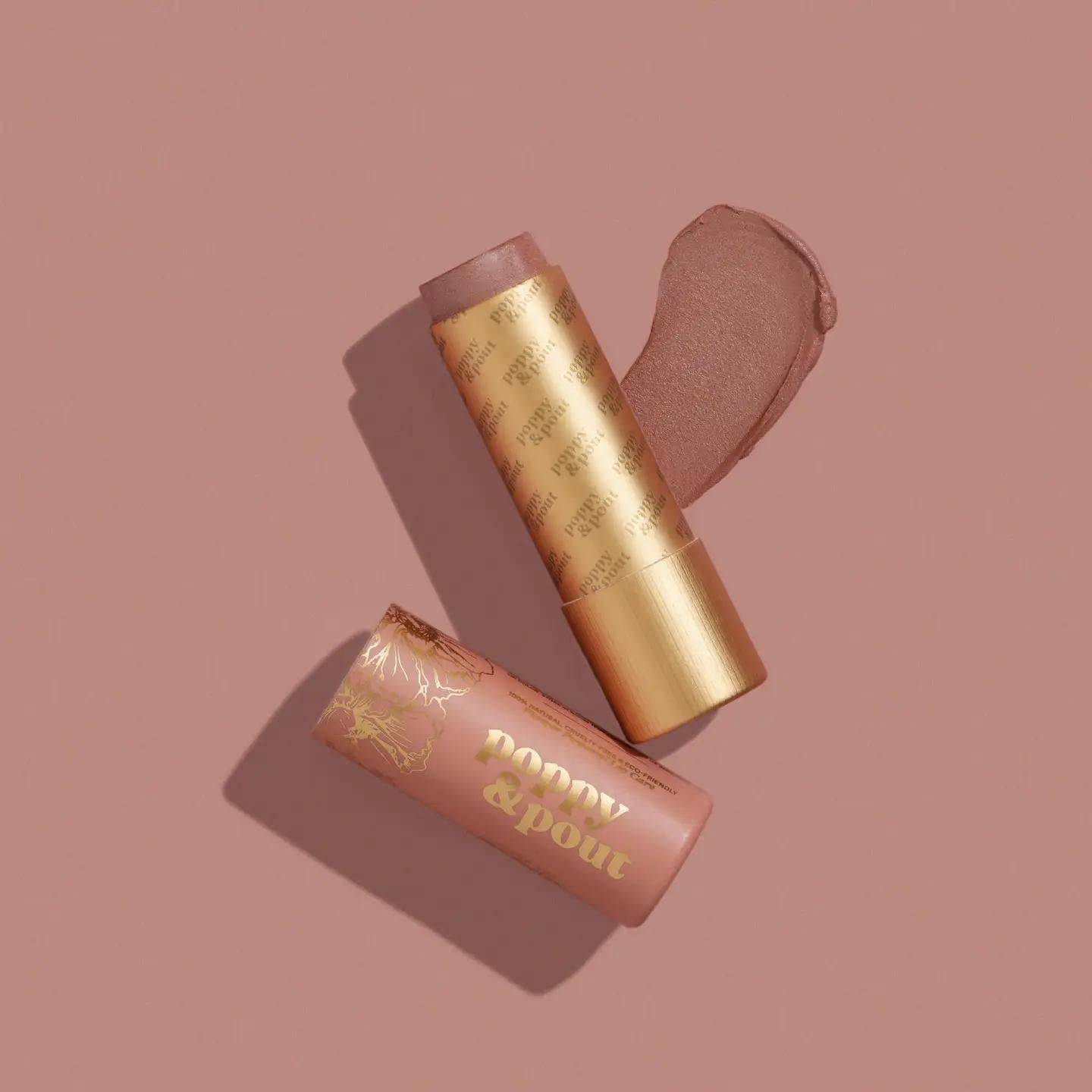 Lip tint in gold tube with nude applicator tip and another tube, peach-pink shade