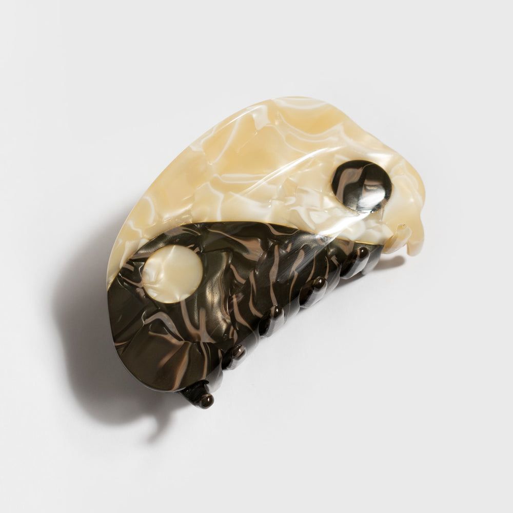 Large hair claw clip with neutral cream and black yin-yang swirl design, curved prongs
