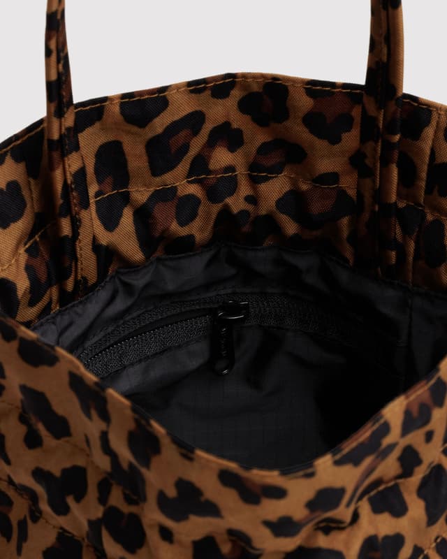 Leopard print nylon drawstring bag with black interior and front zip pocket