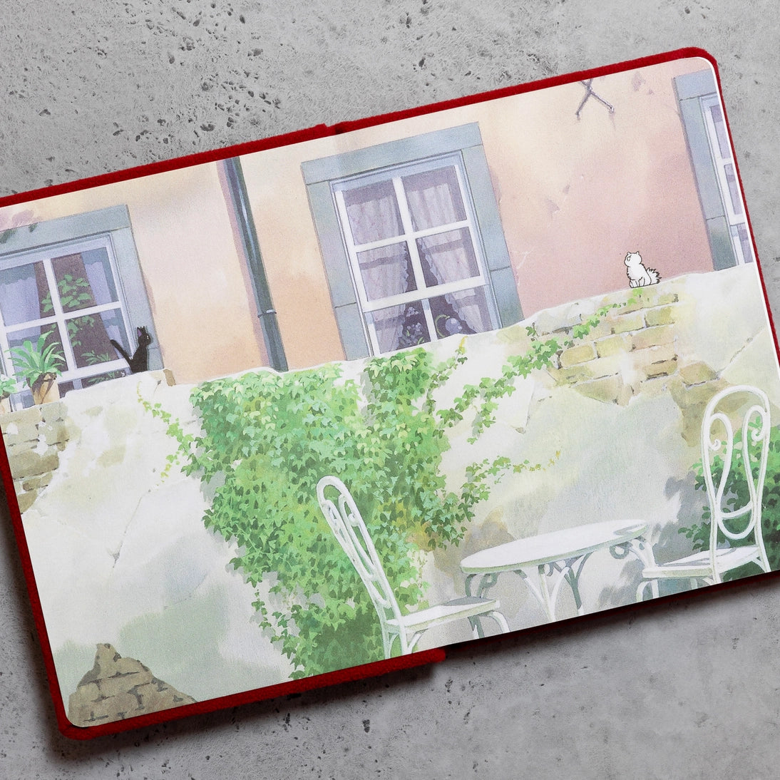 Open plush journal with illustrated garden scene and chairs across lined pages
