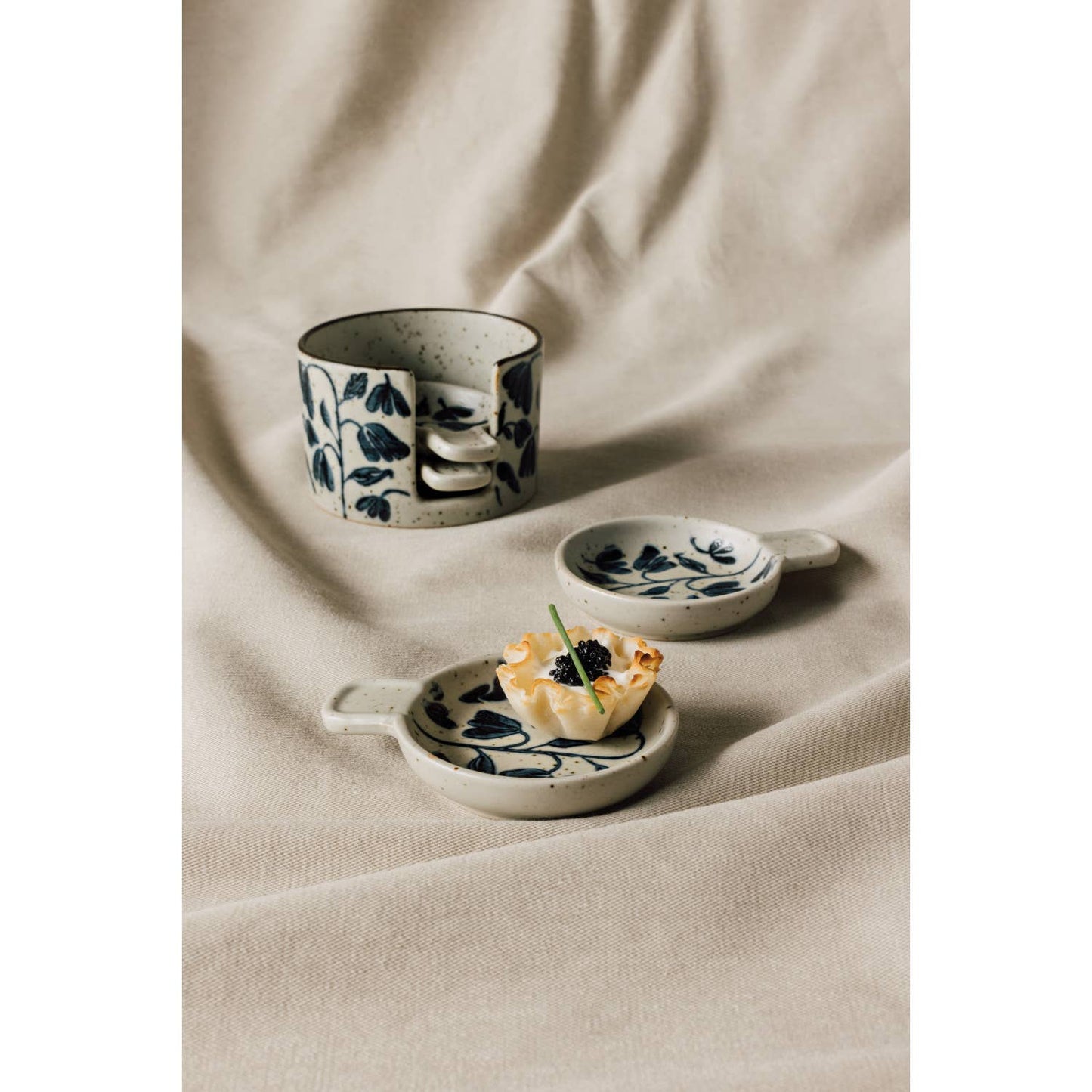 Amuse bouche plate set of four, off-white ceramic with blue posy floral, on cloth