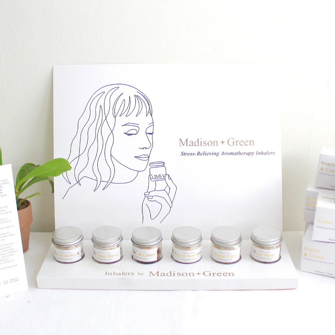Aromatherapy inhaler display with illustrated yoga inhaler card and several small jars