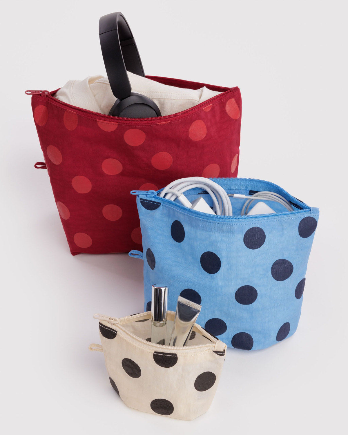 Set of three polka dot zip pouches: red, blue, and beige with navy dots