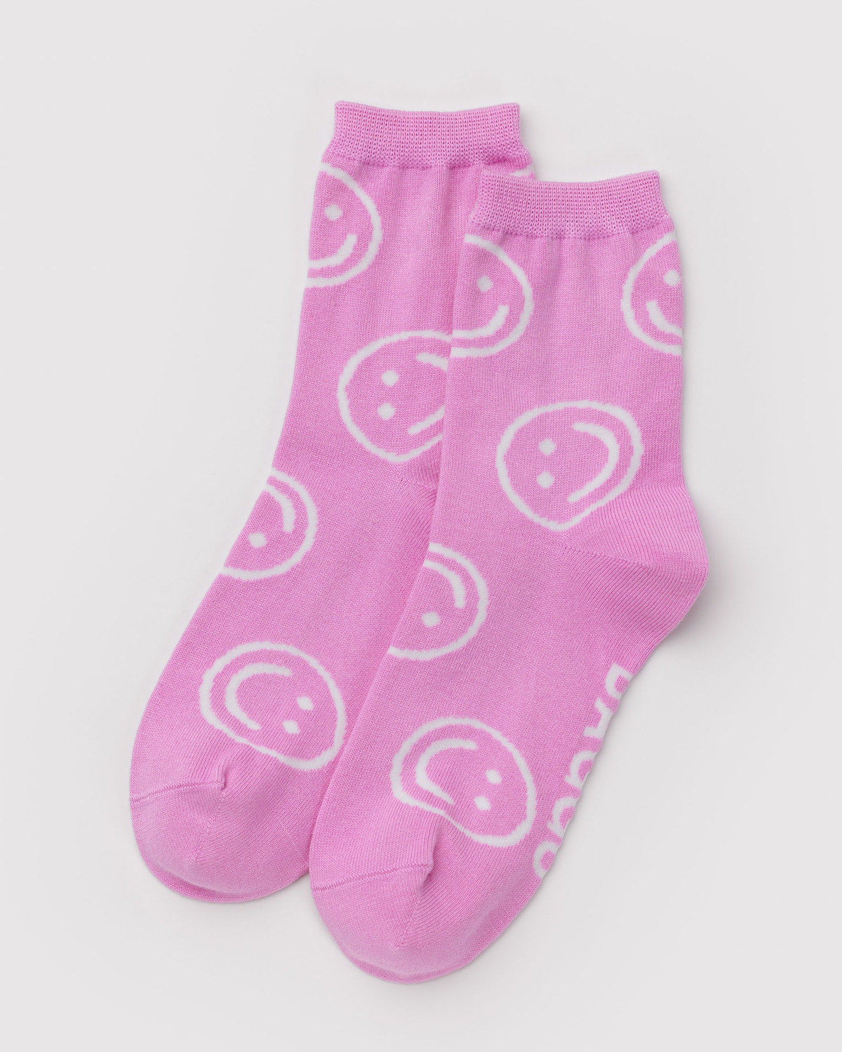 Crew-length socks in pink with white smiley face pattern, two-pack view.