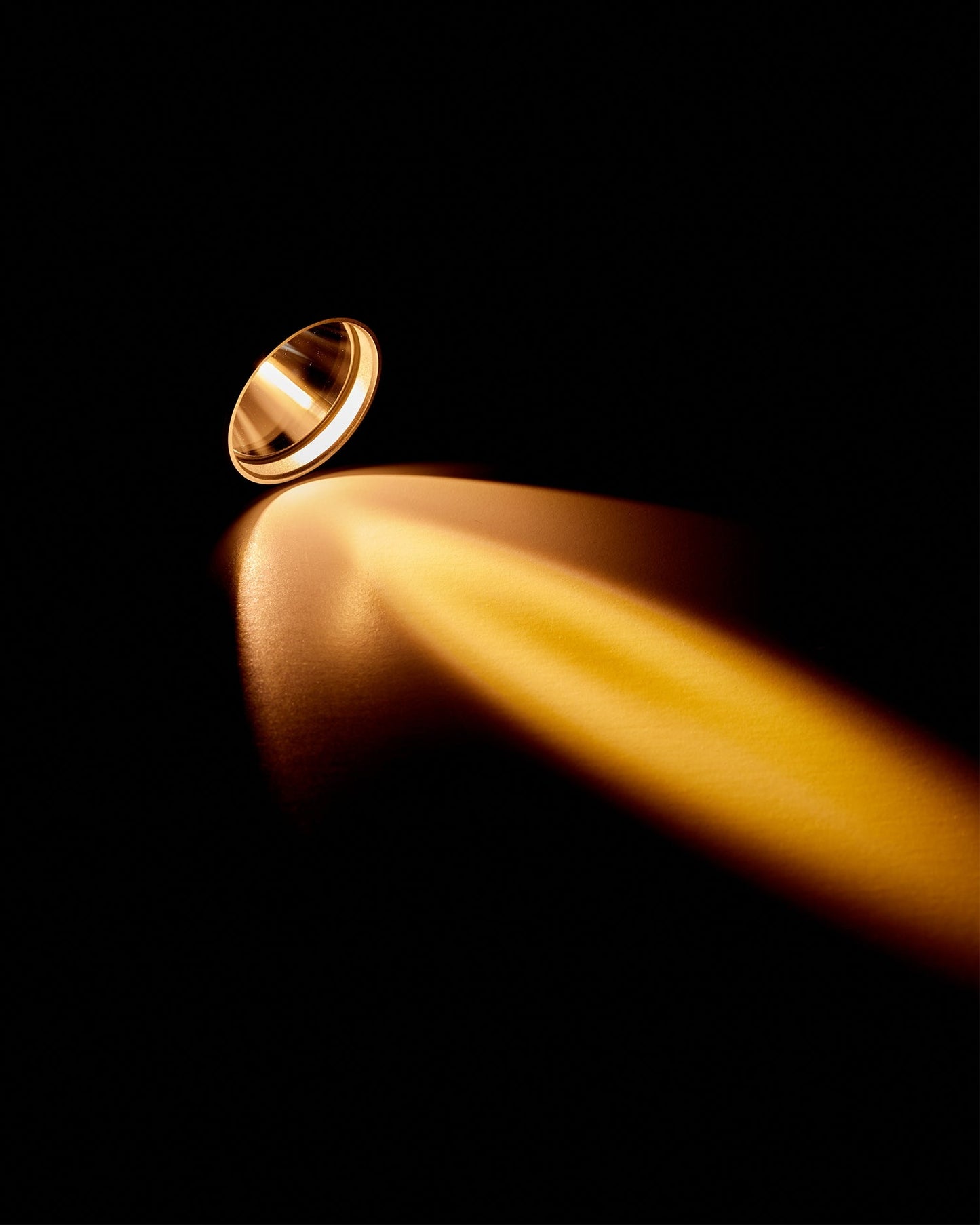 Silver flashlight tip shining warm light beam