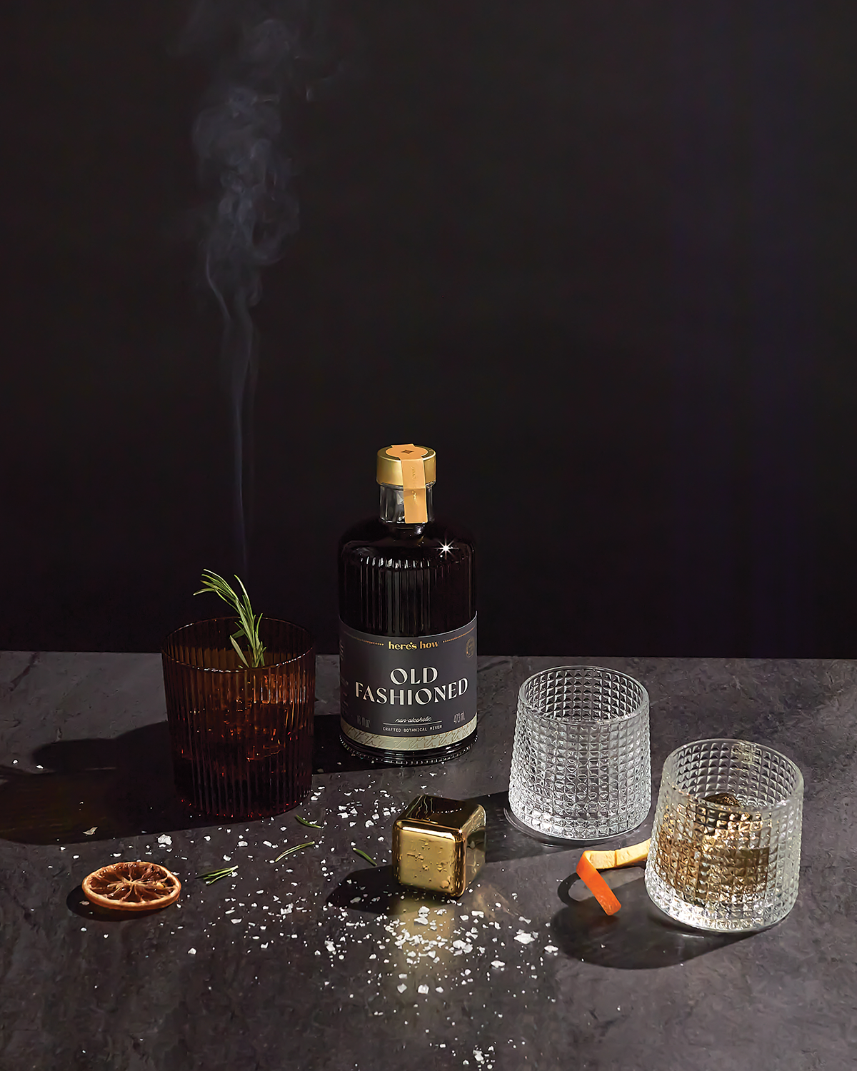 Gold metal cocktail chiller cubes on tabletop near drink glasses