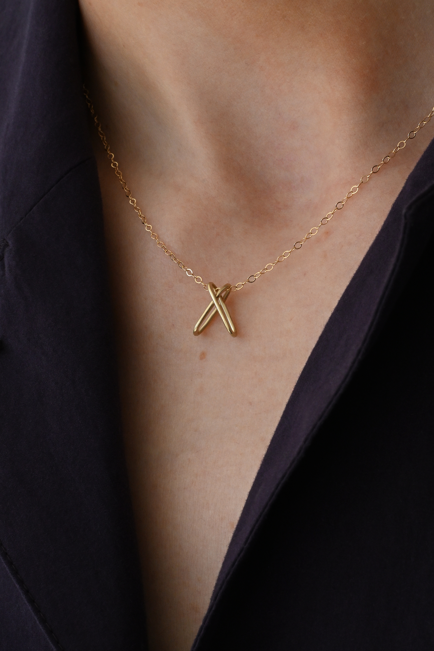 Brass chain necklace with X-shaped pendant at center front