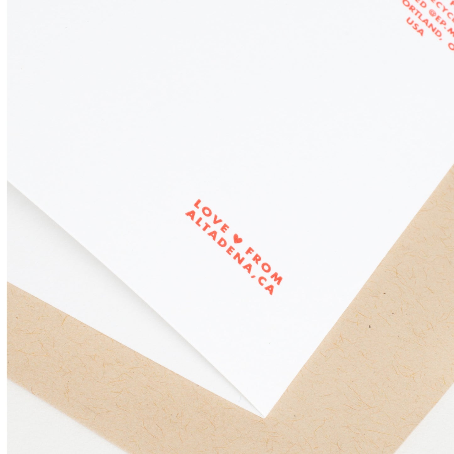 Card corner with red letterpress "LOVE FROM..." text and a kraft envelope