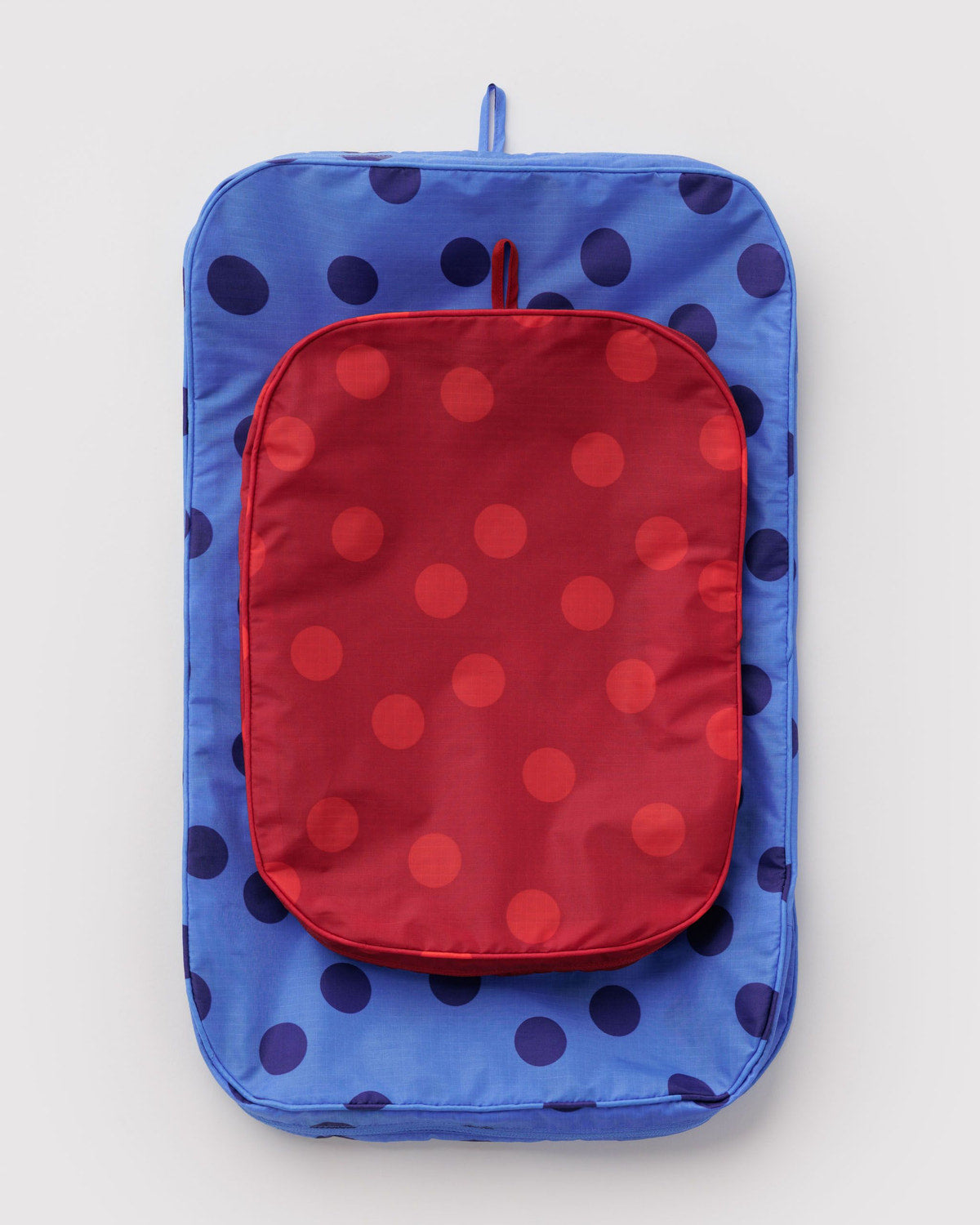 Large packing cube with blue polka-dot fabric and red zip pouch panel