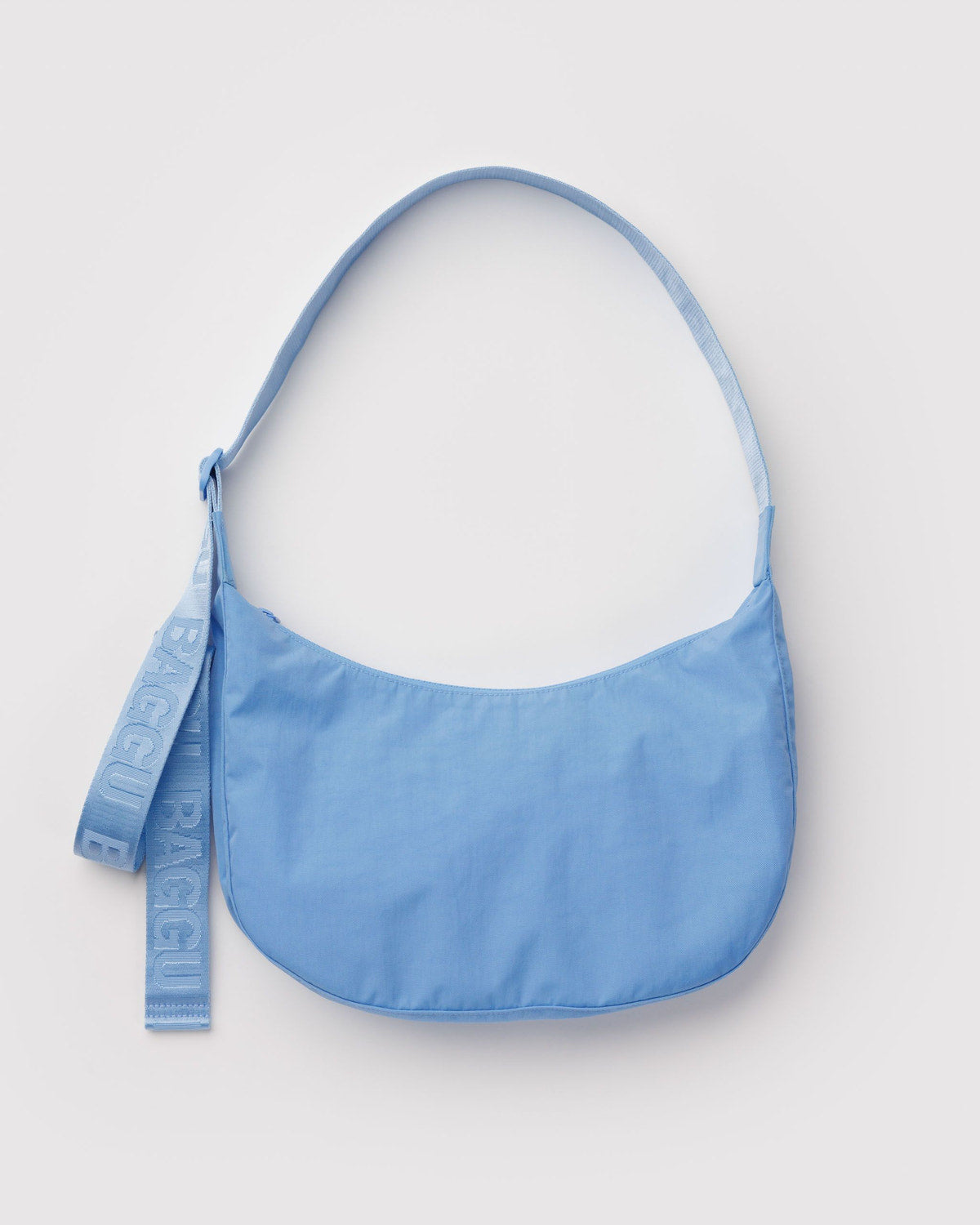 Medium nylon crescent bag in blue with long strap and hanging logo tag