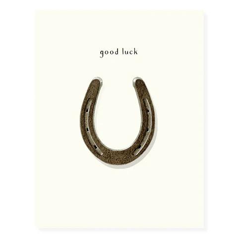 Greeting card with dark brown horseshoe and 'good luck' lettering