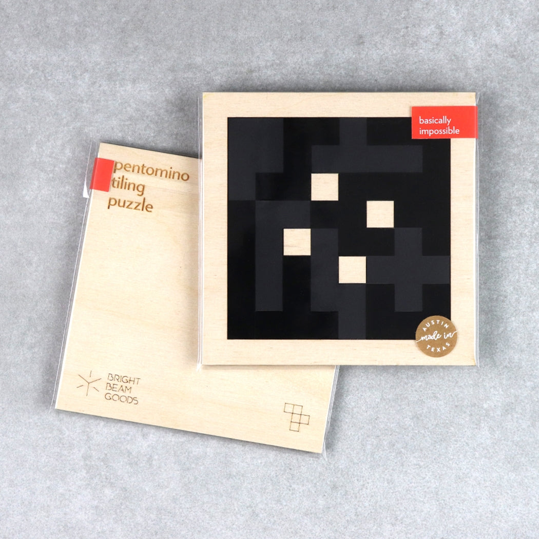 Charcoal square pentomino puzzle set in wooden box with instruction booklet