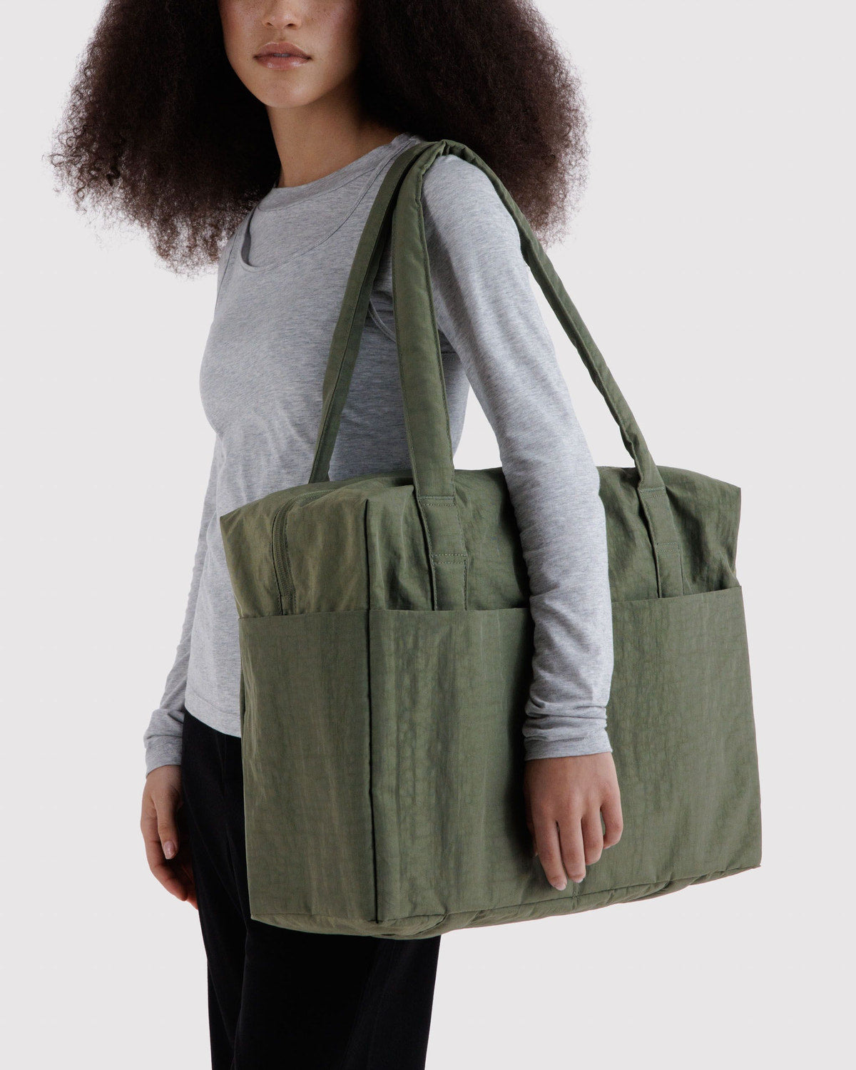 Carry-on bag in olive green with front pocket, side compartments, and handles