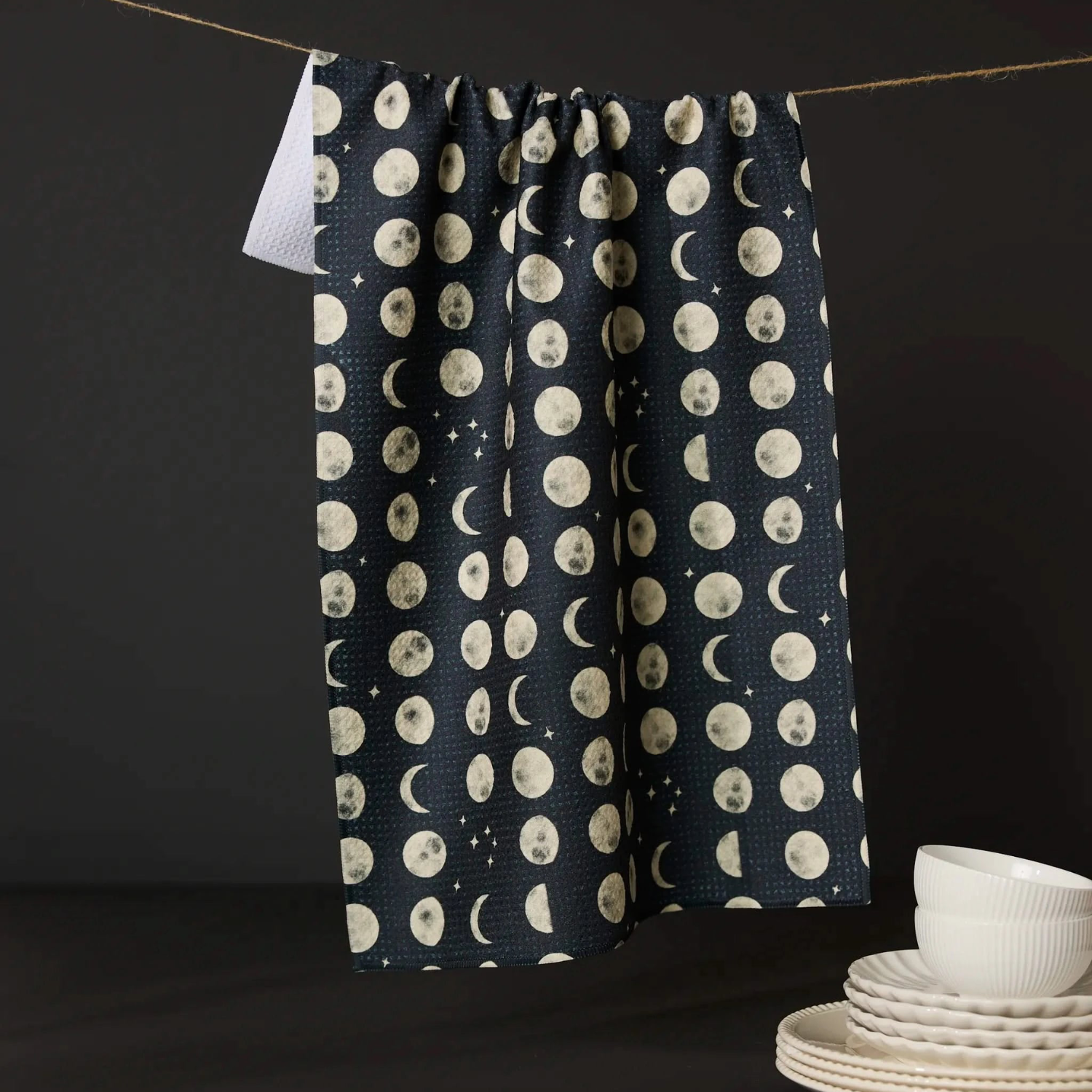 Kitchen tea towel with navy fabric, white moon and dot pattern, hanging loop