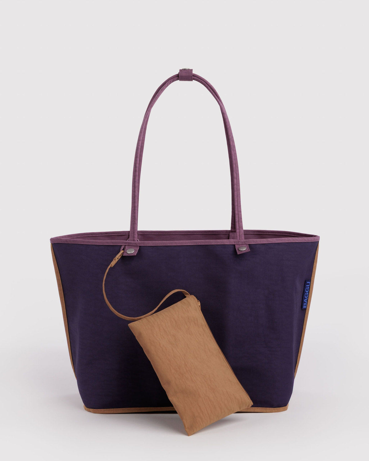 Large nylon reversible tote with dark navy exterior and attached tan folded accessory