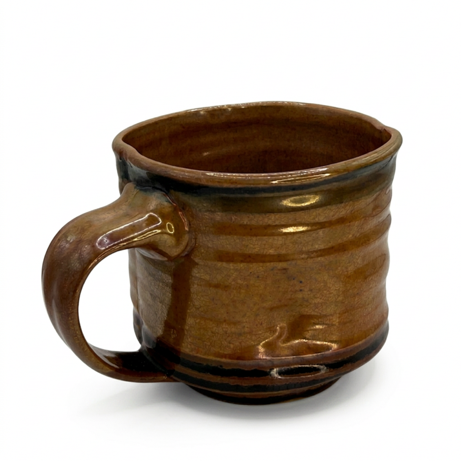 Gloss brown ceramic mug angled view, showing side handle and dark glazed rim