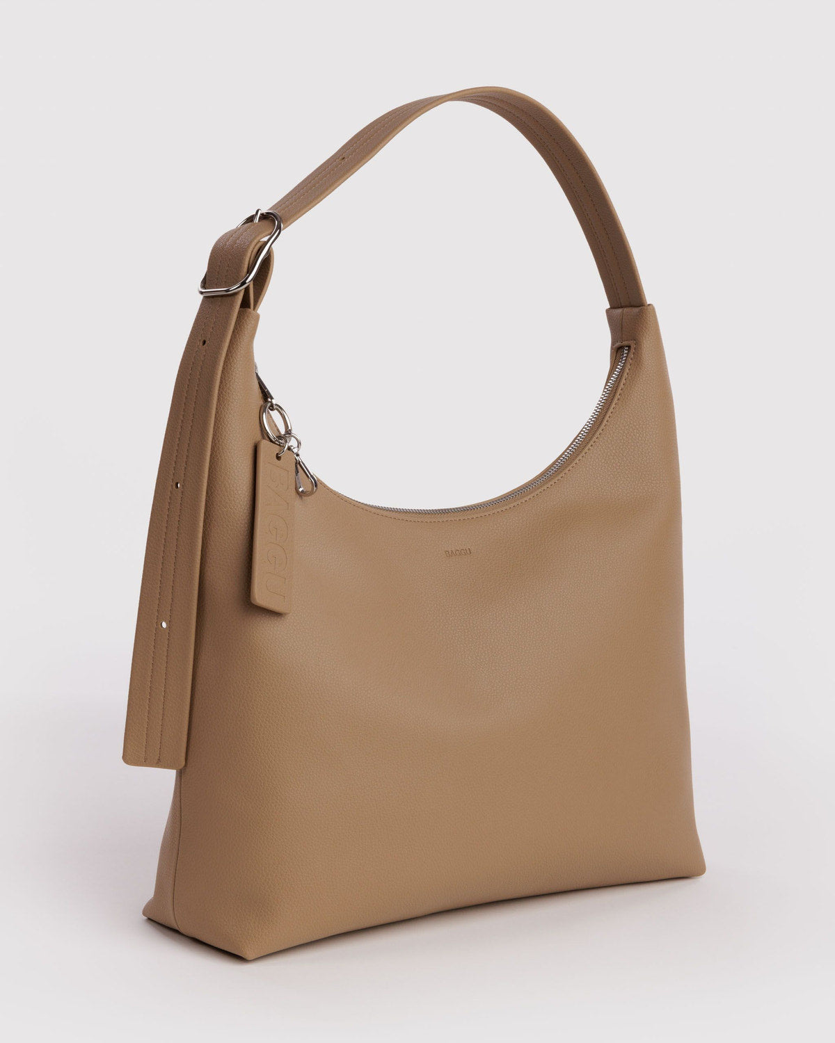 Camel beige recycled leather shoulder bag with top handle and hanging charm, angled view