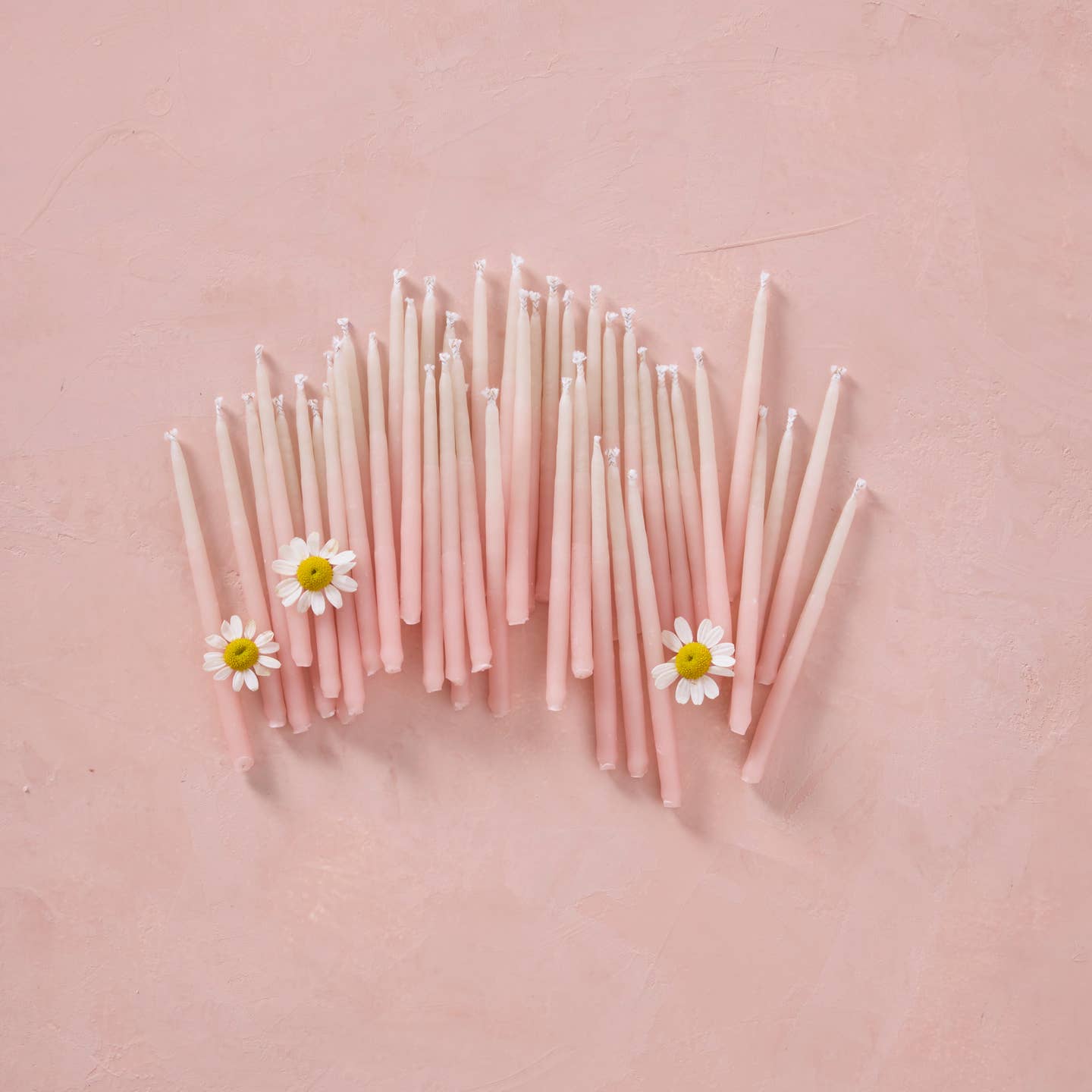 Pink ombre beeswax party candles with daisy toppers, slender pastel pink tapers